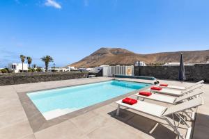 a swimming pool with two lounge chairs and a swimming pool at Villa Yaiza Secret 2 in Yaiza