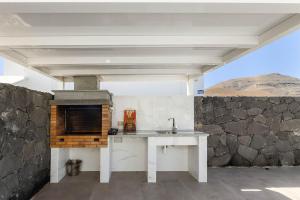 a kitchen with a sink and a stone wall at Villa Yaiza Secret 2 in Yaiza