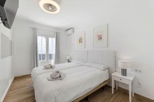 a white bedroom with a large bed and a window at Villa Yaiza Secret 2 in Yaiza