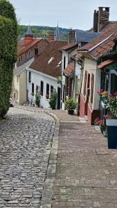 a cobblestone street in a town with houses at L'Hermitage in Auxi-le-Château