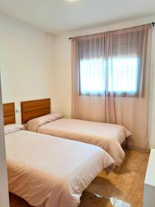 Dos camas en una habitación con ventana. en apartamento aguadulce playa con WIFI, en Aguadulce 14 fotos más