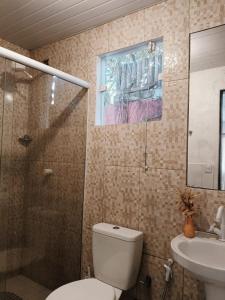 Un baño con inodoro, ducha y lavabo. en Tuiskoms Pousada, en Búzios