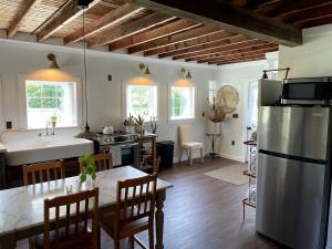 Cottage That Overlooks The Field的厨房以及带不锈钢冰箱的用餐室。 更多70张照片