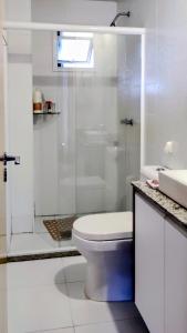 ein weißes Badezimmer mit Toilette und Dusche in der Unterkunft AP Vista do Parque in Cascavel