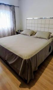 ein großes Bett in einem Zimmer mit einem großen Bett sidx sidx in der Unterkunft AP Vista do Parque in Cascavel