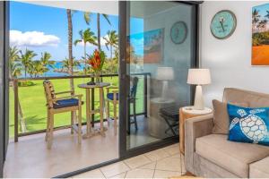 a living room with a couch and a view of the ocean at KIHEI SURFSIDE, #310 condo in Wailea