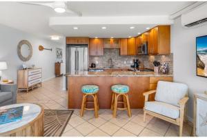 a kitchen with a bar and two chairs and a table at KIHEI SURFSIDE, #310 condo in Wailea +33 photos