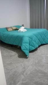 a green comforter on a bed in a room at Dionycio in Cafayate