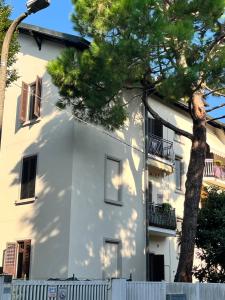 a white building with a tree in front of it at Agaphouse Loft in Milan in Cusano Milanino