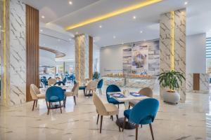 un restaurant avec des tables et des chaises dans un hall dans l'établissement Hurghada Long Beach Resort, à Hurghada