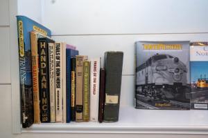 a shelf with several books on a wall at Cozy Caboose Retreat | Sleeps 4 | Fire Pit in Fredericktown