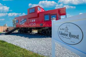 a red train is on display next to a sign at Cozy Caboose Retreat | Sleeps 4 | Fire Pit in Fredericktown