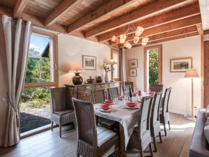 夏蒙尼-勃朗峰Chalet contemporain aux Houches, près des pistes, 6 chambres, WiFi, jardin, grille-pain - FR-1-343-179的有一张长桌子和椅子的餐厅