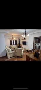 Una sala de estar con dos sofás y una mesa. en Casa el Mure, en Ronda