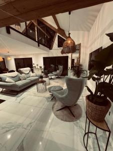 un salon avec un canapé et une chaise dans l'établissement Alt'R & Go Exceptional house, à La Celle-sous-Gouzon