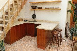 a kitchen with a counter and a sink and stools at Riad Mazal Mogador in Essaouira