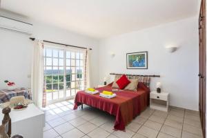una camera da letto con un letto e una grande finestra di Villa Colina do Sol by Villa Plus a Paderne Altre 15 foto