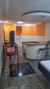 a kitchen with a counter and chairs in a room at Motel Sol Parque Cascavel in Goiânia