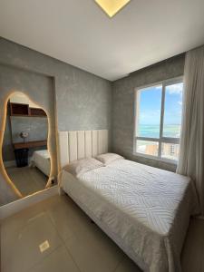 a bedroom with a bed and a large window at Cobertura dúplex frente mar in Vila Velha +49 photos