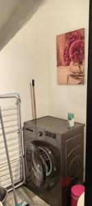 a washing machine in a room with a painting on the wall at Maison de village in Sigean +1 photo