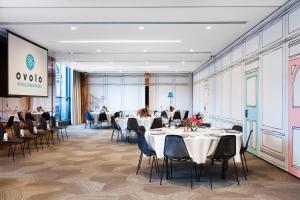 a conference room with tables and chairs and a screen at Ovolo Woolloomooloo in Sydney