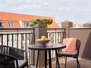 a table with a bowl of lemons on a balcony at Numa Berlin Novela in Berlin