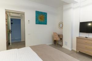 a bedroom with a bed and a desk and a television at Troia Boutique Hotel in Rîmnicu Sărat