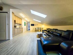 a living room with black leather furniture and a kitchen at Troia Boutique in Rîmnicu Sărat