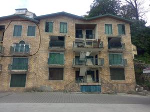 a brick building with windows and balconies at muree cottage in Murree