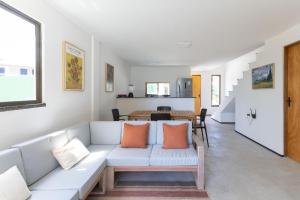 a living room with a white couch with orange pillows at Beachfront Duplex #A6 - Aquiráz By Carpediem in Aquiraz