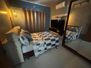 1 dormitorio con 1 cama, TV y espejo en Casa aconchegante no litoral do Piauí, ao lado da Iesvap e Assaí Supermercado, en Parnaíba