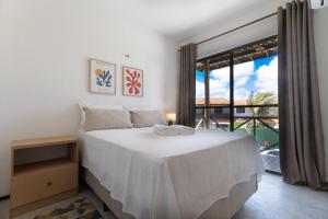 a bedroom with a white bed and a large window at Beachfront Duplex #A6 - Aquiráz By Carpediem in Aquiraz +43 photos