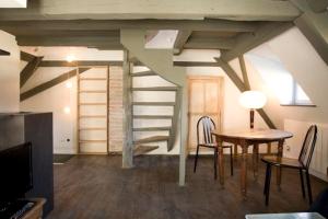 a living room with a table and a spiral staircase at L'appartement au-dessus du in Strasbourg