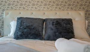 a bed with two black pillows on it at Tiny Home in Balm Beach