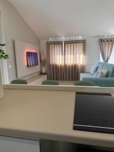 un salon avec une table avec un ordinateur portable dessus dans l'établissement Hana Luxury Rooftop Milano Nord, à Cinisello Balsamo