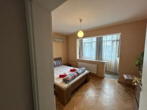 ein Schlafzimmer mit einem Bett und einem großen Fenster in der Unterkunft Апартаменти Уют in Plowdiw