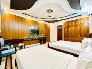 a hotel room with two beds and a tv at Drop inn in Islamabad