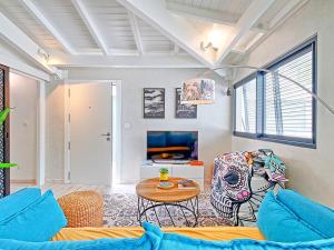 a living room with a couch and a table at Superbe appartement 2 chambres à Anse Marcel, 400m des plages, activités nautiques incluses - FR-1-734-44 in Anse Marcel 
