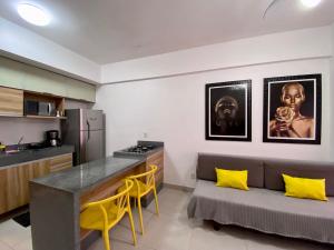 a kitchen with yellow chairs and a couch in a room at Studio Unique 2802 com garagem á 15 min do centro de Belém in Belém