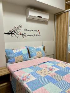 a bedroom with a bed with a quilt at Studio Unique 2802 com garagem á 15 min do centro de Belém in Belém