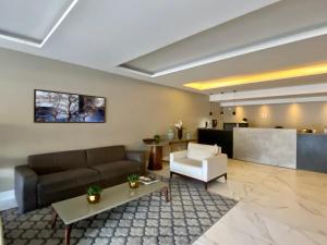 a living room with a couch and a table at Studio Unique 2802 com garagem á 15 min do centro de Belém in Belém