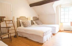 a bedroom with two beds and a chair and a window at Charmant manoir Sud de Paris in Saint-Sauveur-sur-École +47 photos