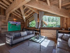 a living room with a couch and a tv in a cabin at Chalet à Chamonix avec Sauna et Jacuzzi - FR-1-343-253 in Chamonix-Mont-Blanc