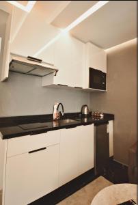 Una cocina con gabinetes blancos y un fregadero. en Luxurious apartment with private jacuzzi, en Marrakech 3 fotos más