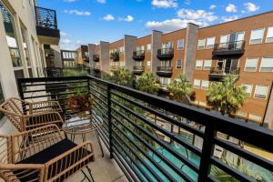 a balcony with chairs and tables and buildings at Lookout Luxe 2BR | King + Q/Q Bunk | Shuffleboard in Audelia