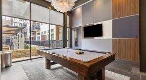 a pool table in a room with a tv at Lookout Luxe 2BR | King + Q/Q Bunk | Shuffleboard in Audelia