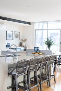 Una cocina con un mostrador con sillas alrededor. en Beachfront Haven Magenta, en Magenta