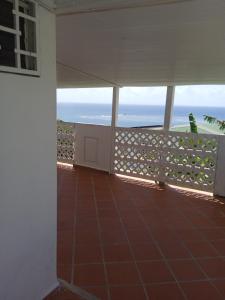 a view of the ocean from the balcony of a house at Les jardins de VALENTIN in Le Gosier