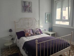 a bedroom with a bed with purple sheets and pillows at Oasis in A Coruña