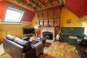 Una sala de estar con muebles de cuero y chimenea. en Salem The Blue Chapel, en Llwyngwril